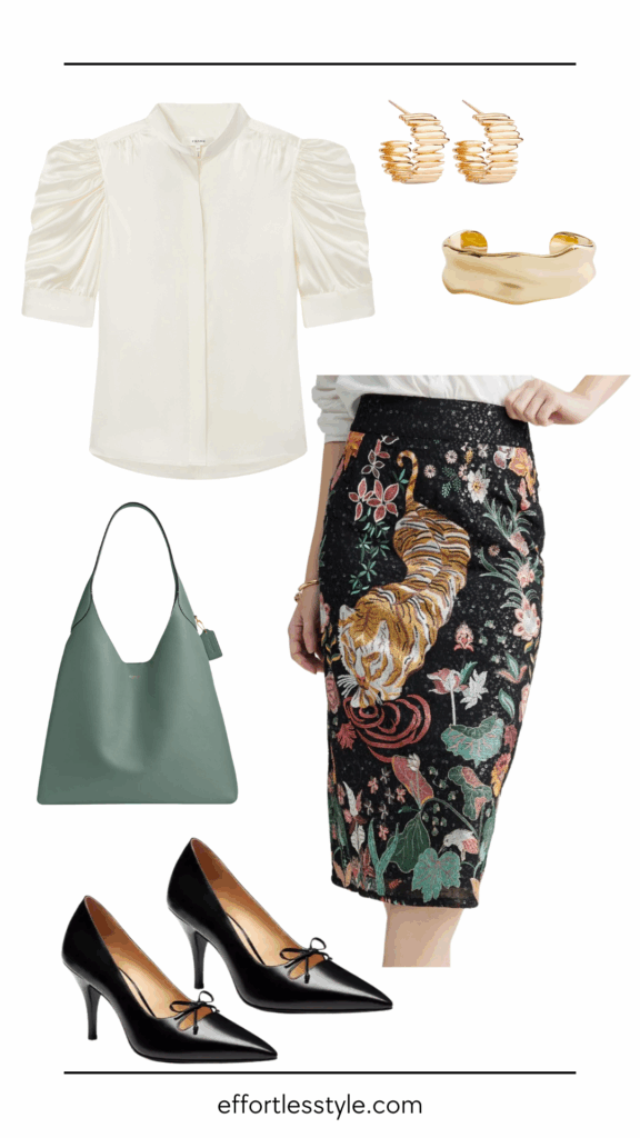 Rule of Thirds Flat lay of an office-ready outfit featuring a cream ruched-sleeve blouse, black midi pencil skirt with colorful embroidered tiger and floral design, black pointed-toe heels, green leather shoulder bag, and gold jewelry.