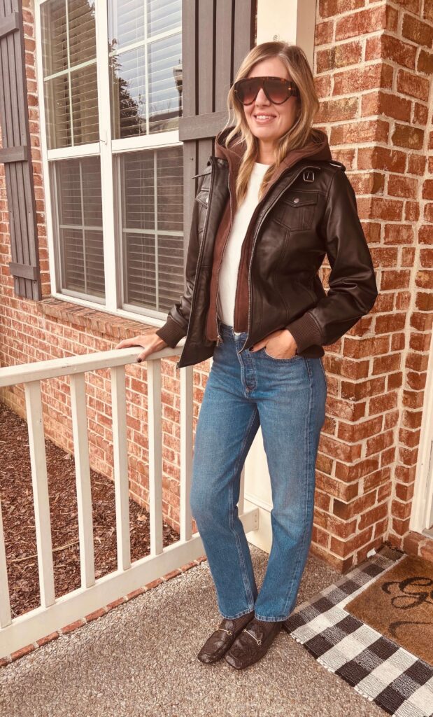 How to Style a Brown Leather Jacket (+ Why Brown Works with Everything) | Brown leather jacket styled with a white tee, straight-leg jeans, brown loafers, and sunglasses for an effortlessly polished vibe. 